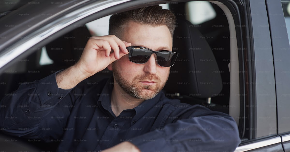 Look élégant. Homme en tenue officielle essayant sa nouvelle voiture ...