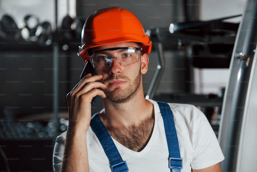 Important conversation. Portrait of engineer in metallurgical factory in protective helmet and eyewear.