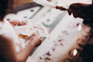 Wedding rings on plate for wedding matrimony in church. Little girl holding wedding rings on plate and priest blessing them with holy water for ceremony.