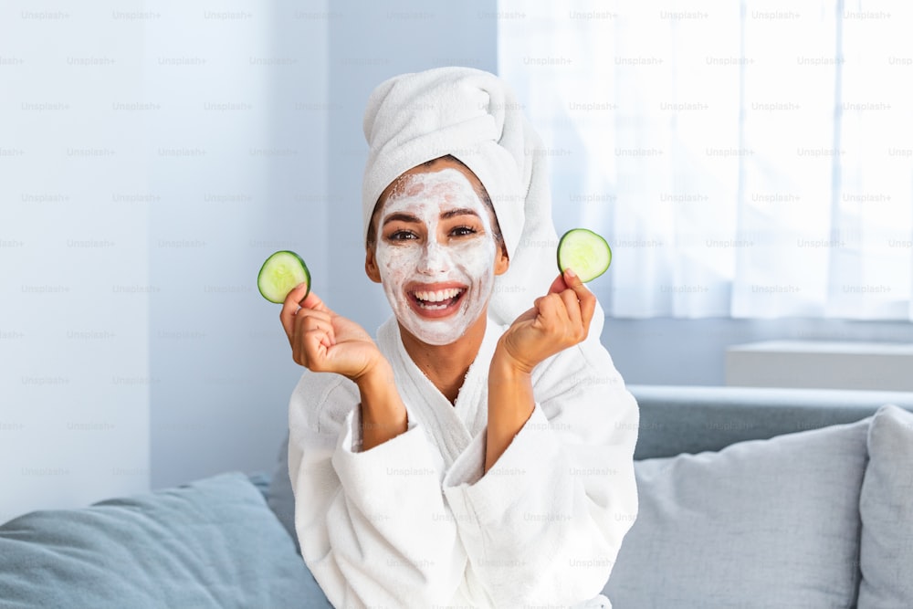 Natural homemade fresh cucumber facial eye pads facial masks. Woman holding cucumber pads and smile relax with natural homemade. Young woman with clay facial mask holding cucumber slices