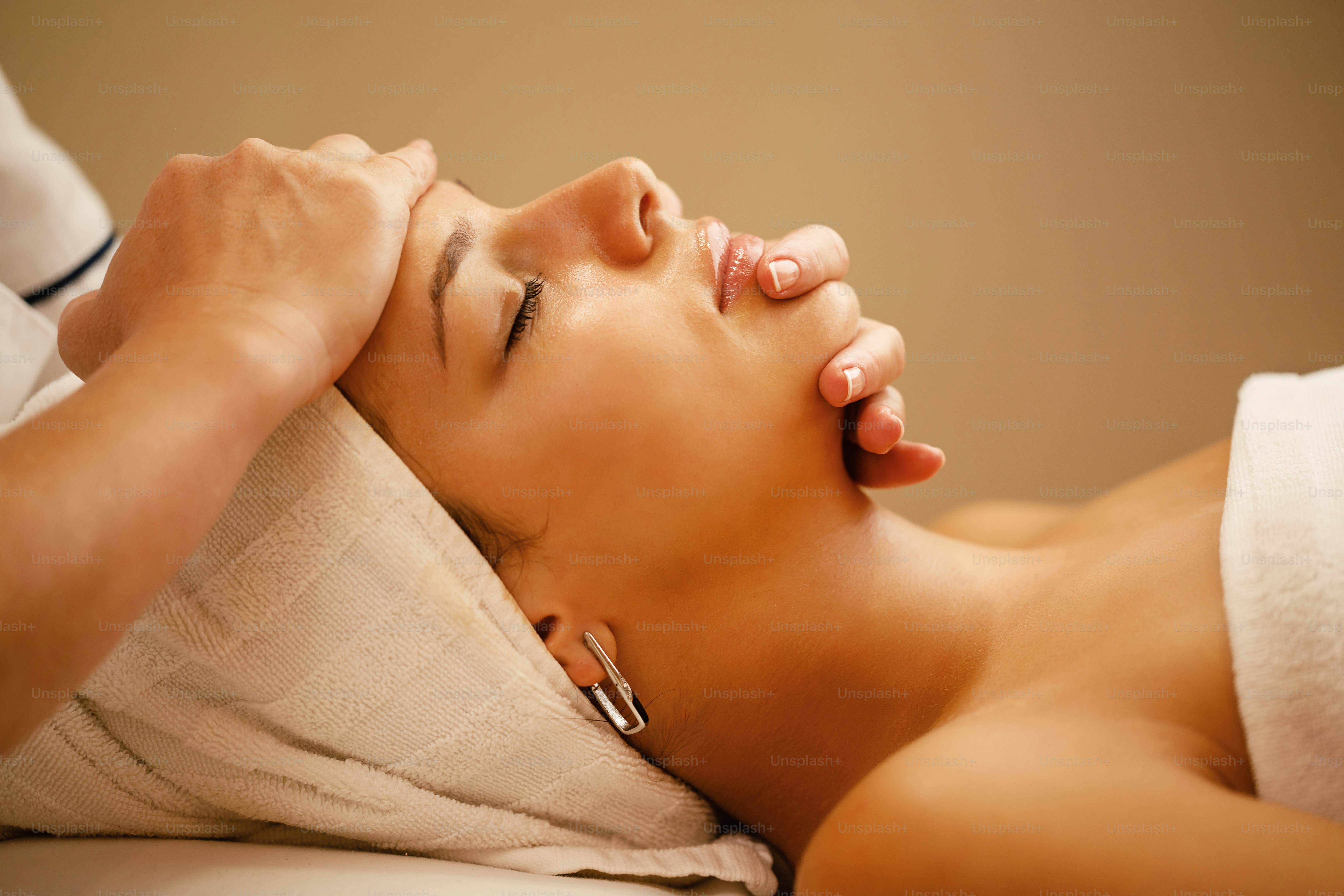 Profilansicht einer schönen Frau, die während der Spa-Behandlung im Schönheitssalon eine Kopfmassage erhält.