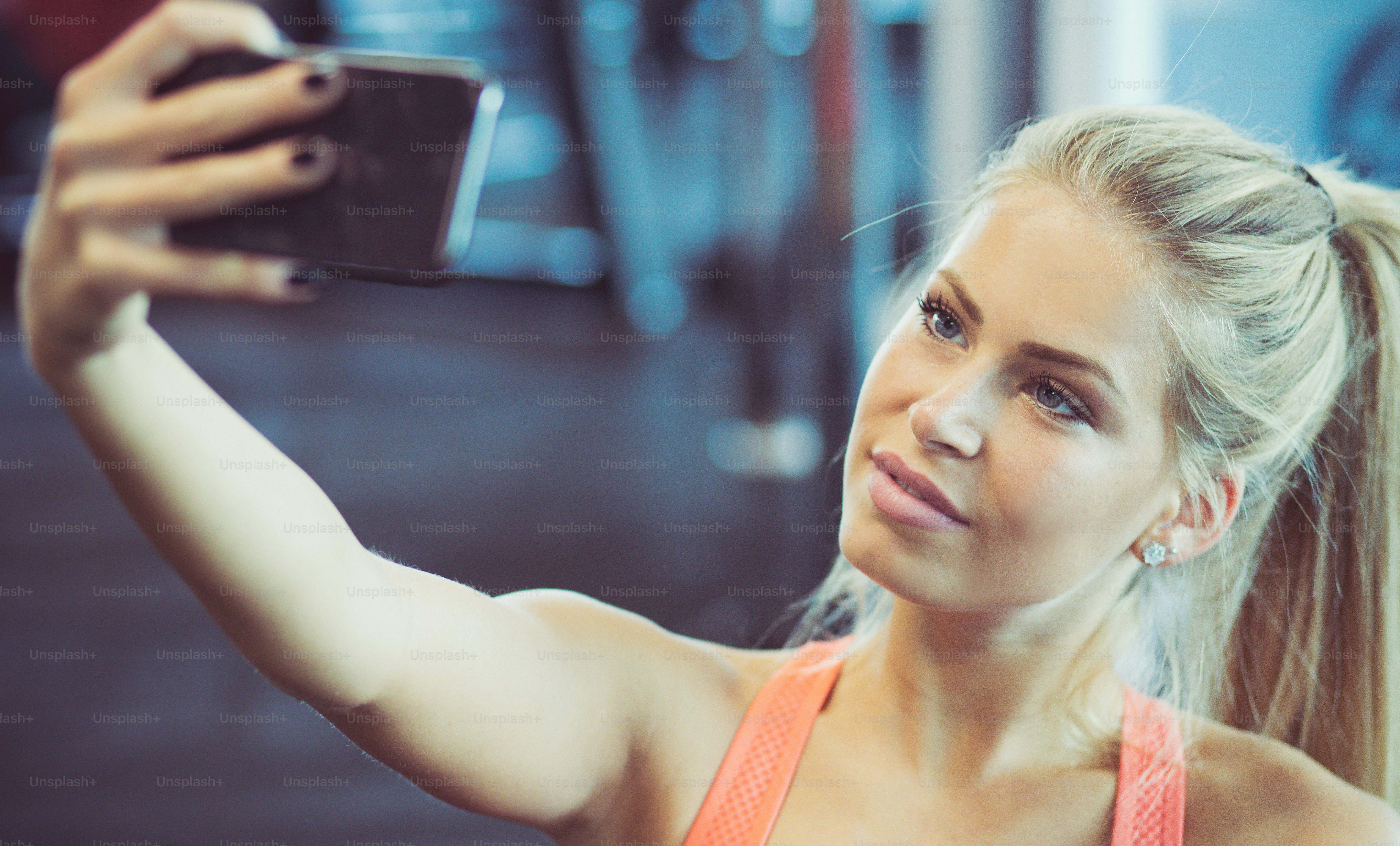 Weil Fitnessstudio selbst nicht optional sind. Frau, die im Fitnessstudio telefoniert.
