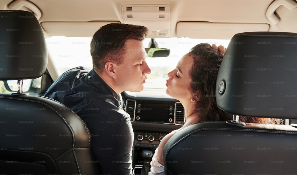 Dare un bacio. Le belle persone sono nell'auto moderna nei loro fine settimana.