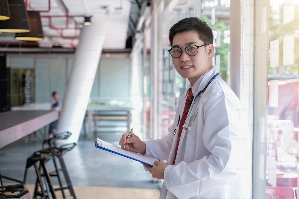 Male doctor writing on clipboard in the office.