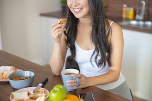 Cropped photo of Asian girl taking breakfast in the kitchen