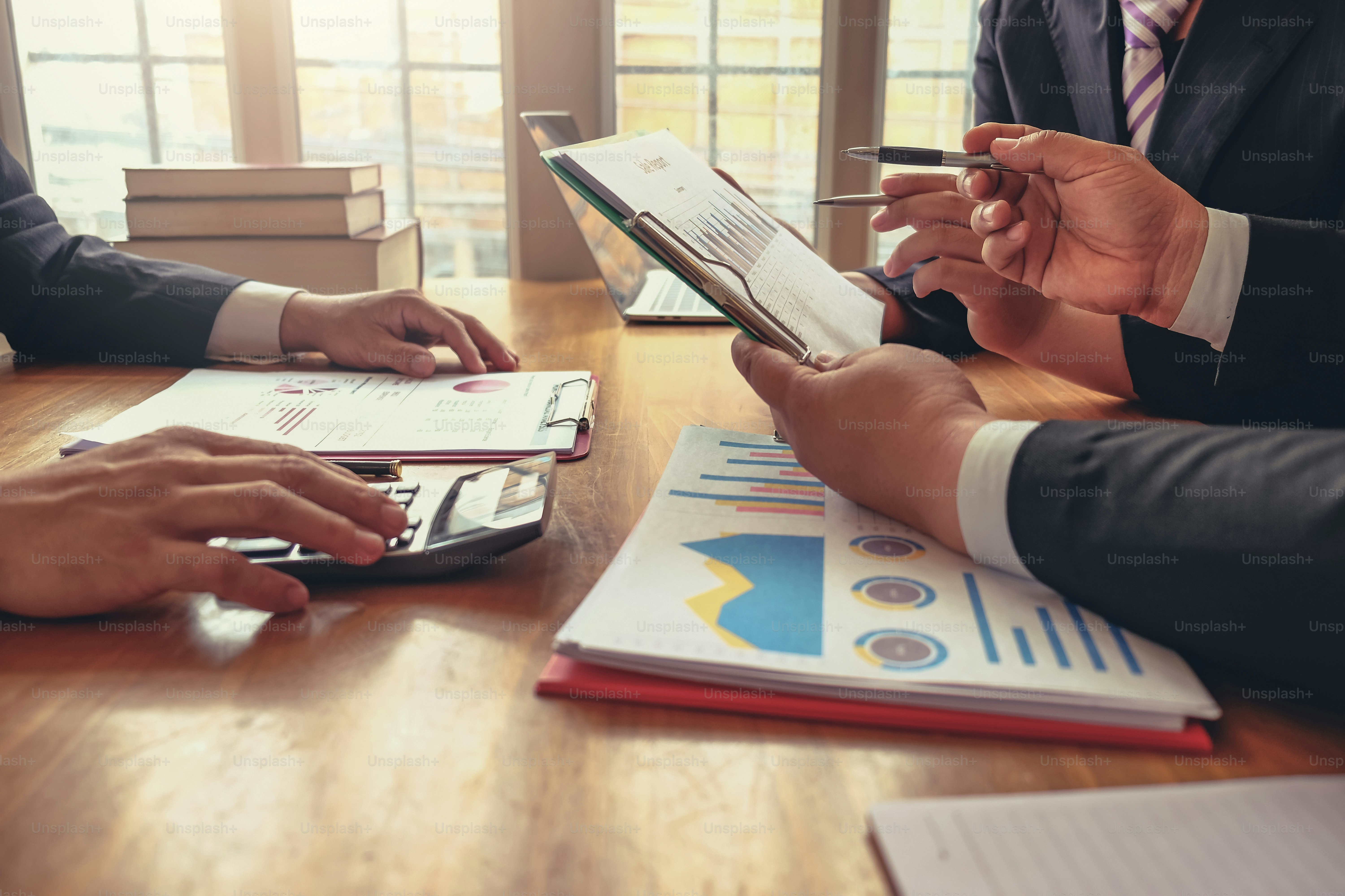 Los empresarios hablan sobre inversiones, planificación de marketing y ven la hoja de datos en el gráfico de datos financieros.