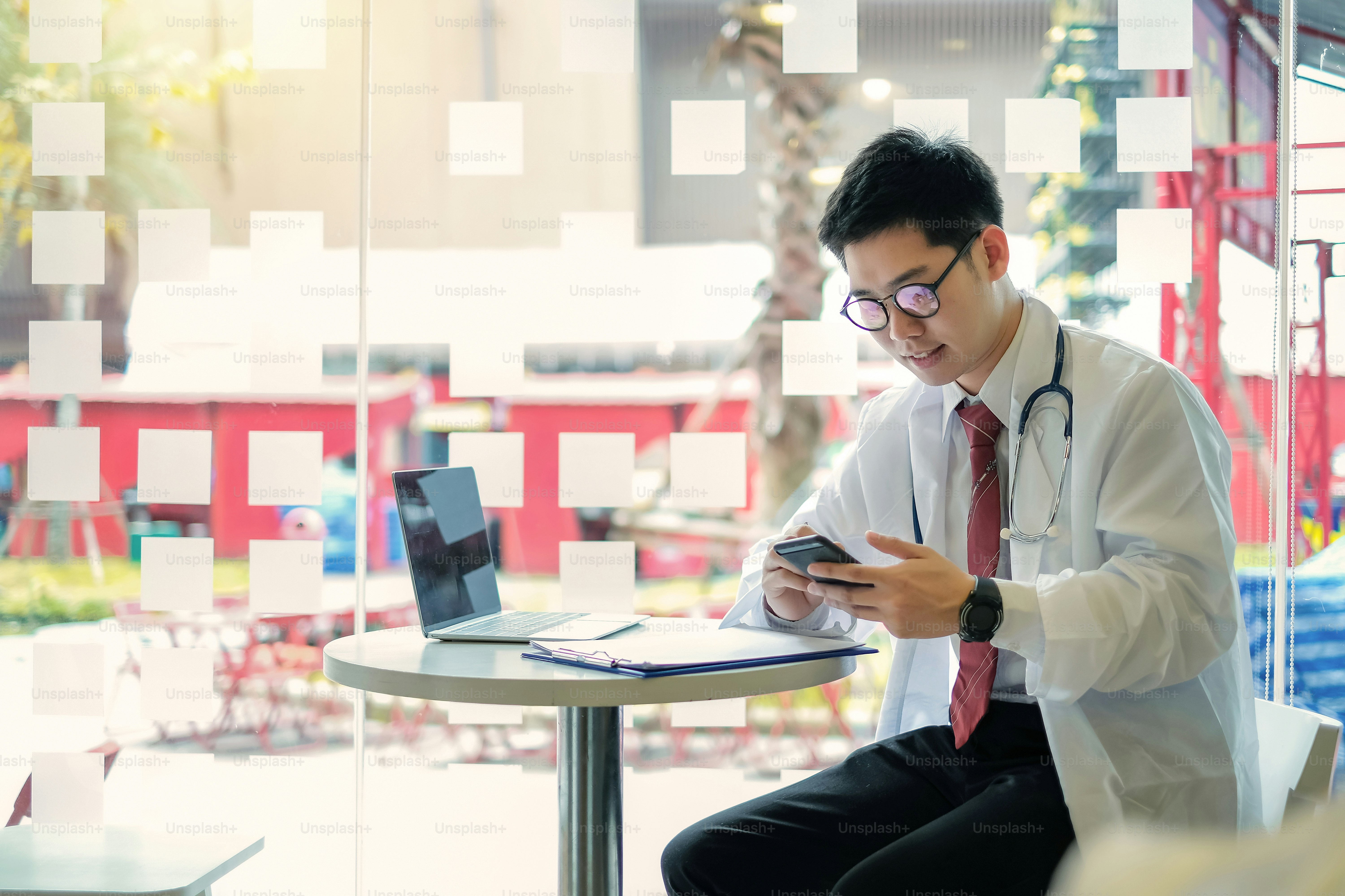 Doctor using mobile phone and text messaging in the office.
