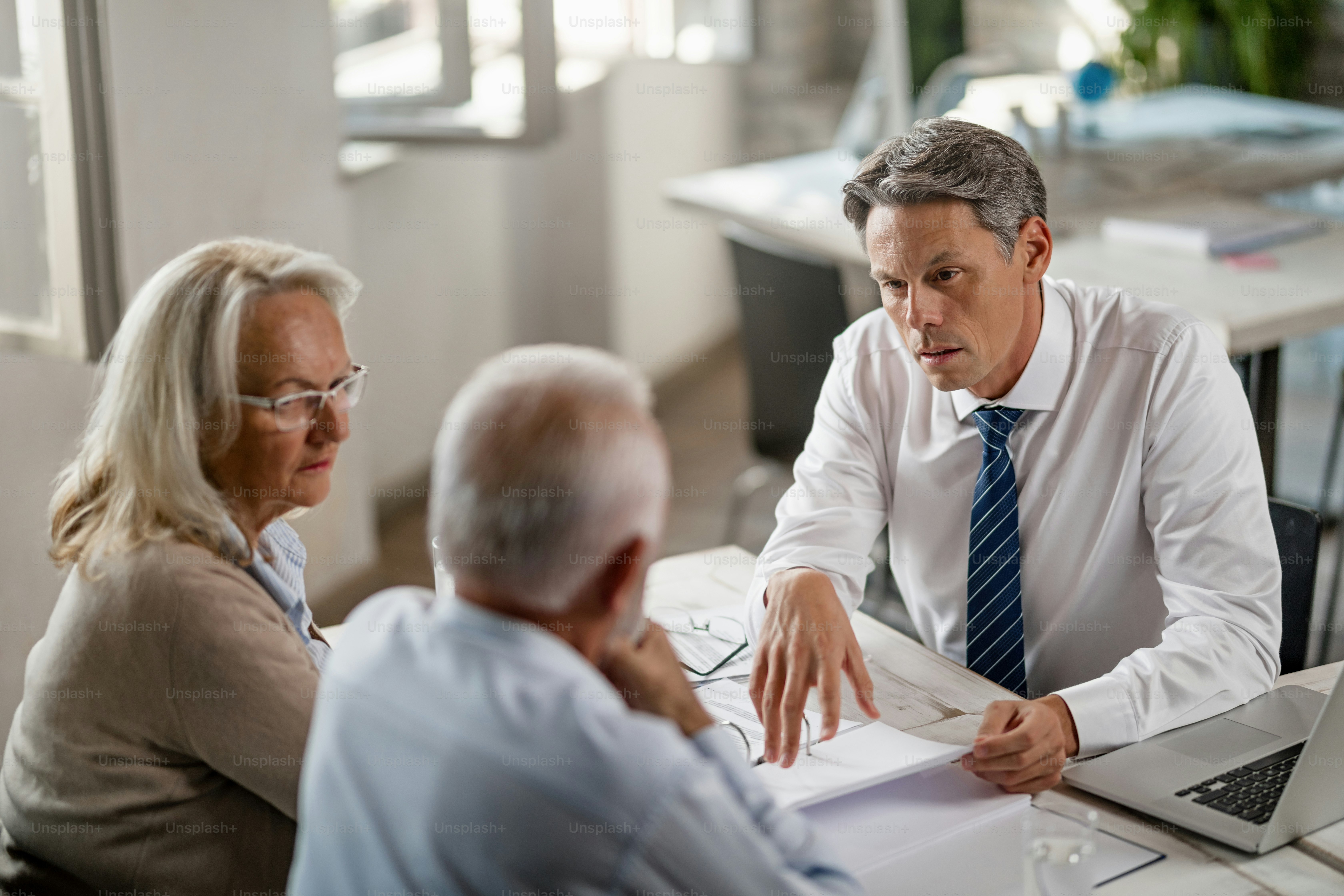 Financial advisor discussing with senior couple about retirement planning