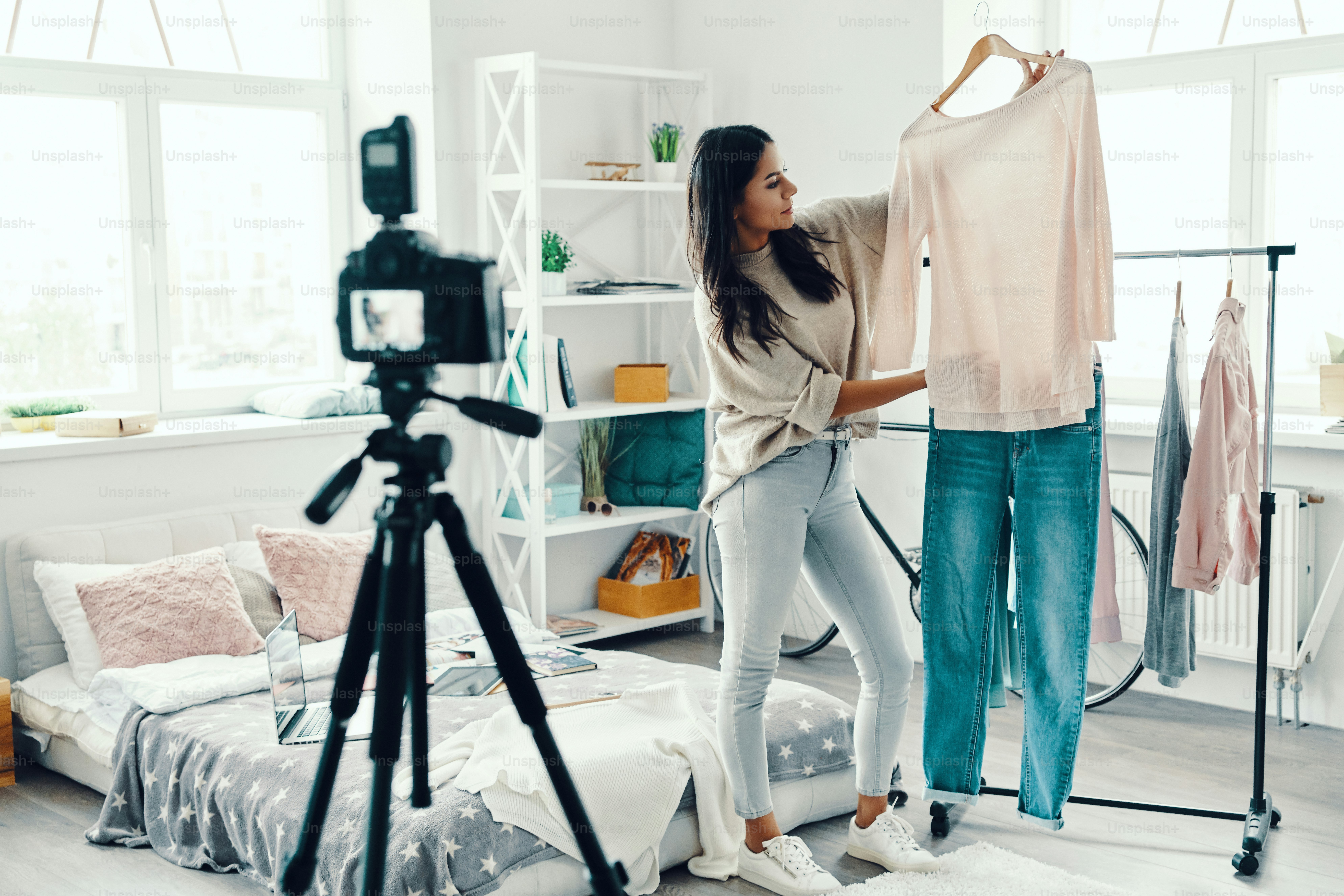 Beautiful young woman in casual clothing making social media video while spending time at home