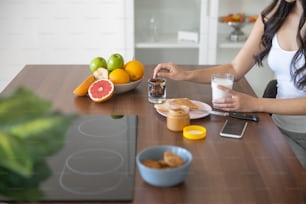 Cropped photo of a woman eating nuts and raisins