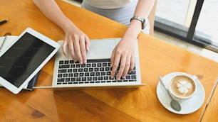 Oben Ansicht weiblich mit Laptop-Computer mit Kaffee Latte.