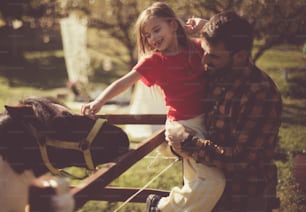 Nurture love for animals. Father and daughter on farm.