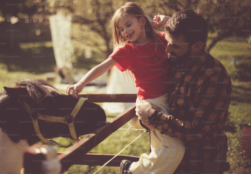 Cultive o amor pelos animais. Pai e filha na fazenda.