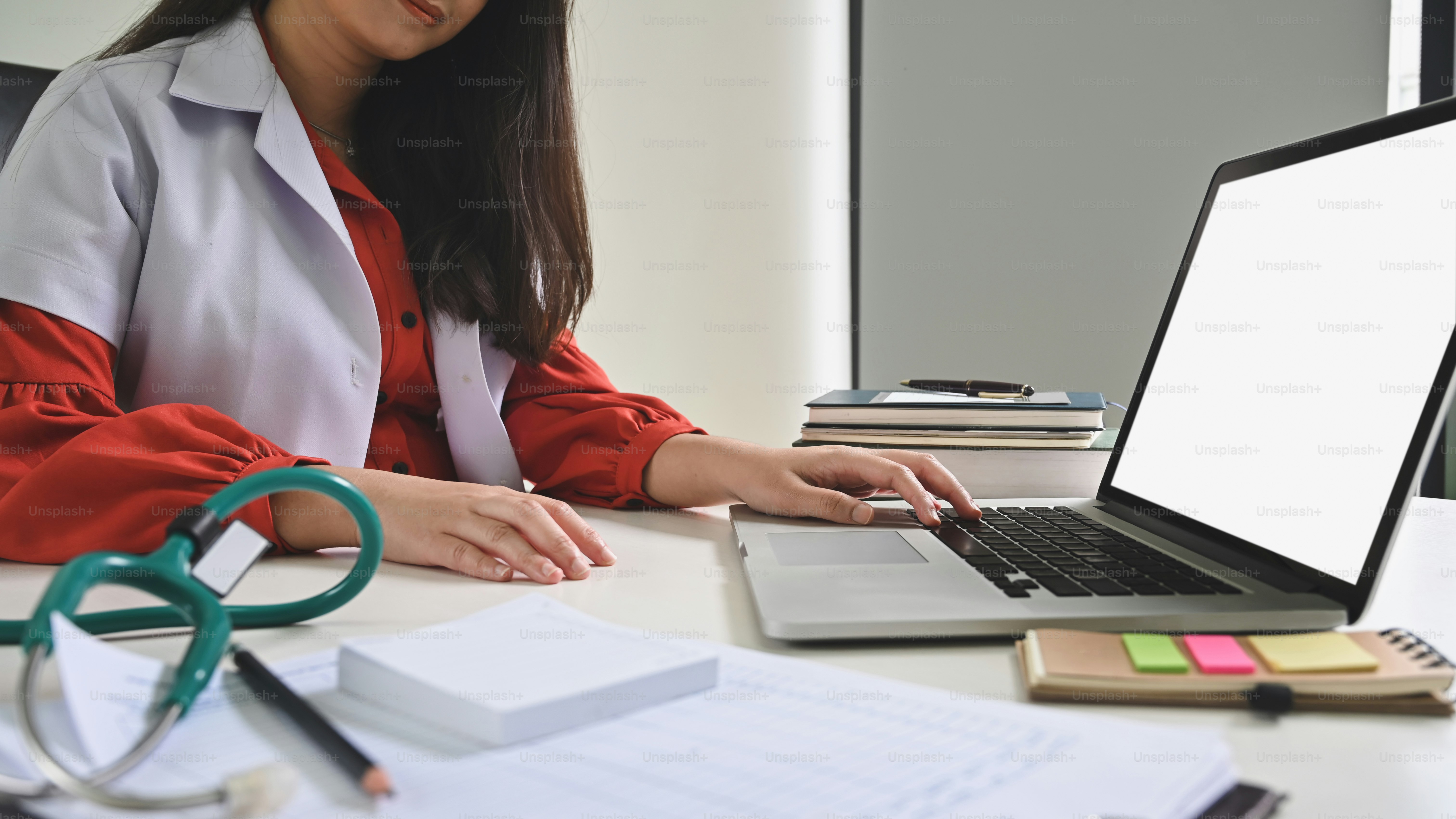 Female doctor using laptop with empty screen computer.