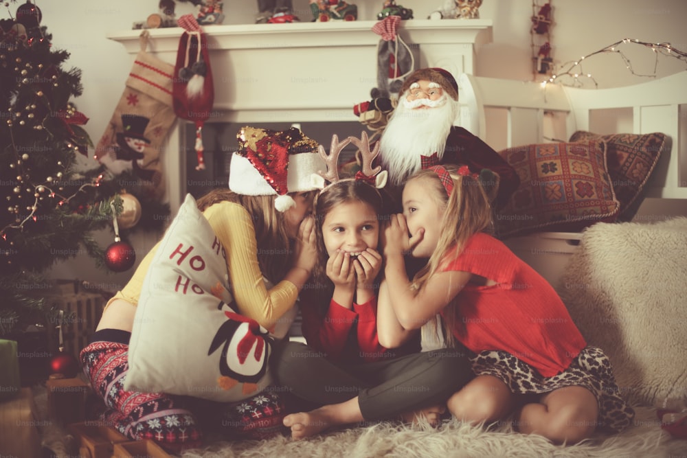 Sharing Christmas secrets. Little girls at home.