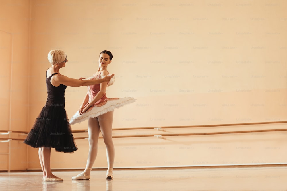 Young ballerina wearing stage costume having rehearsal with her mature instructor. Copy space.