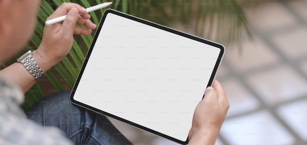 Recortado de jovem empresário profissional usando tablet digital de tela em branco enquanto trabalhava em seu projeto