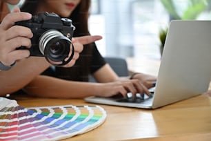 Fotógrafo y socios que trabajan con el concepto de computadora portátil y coloración.