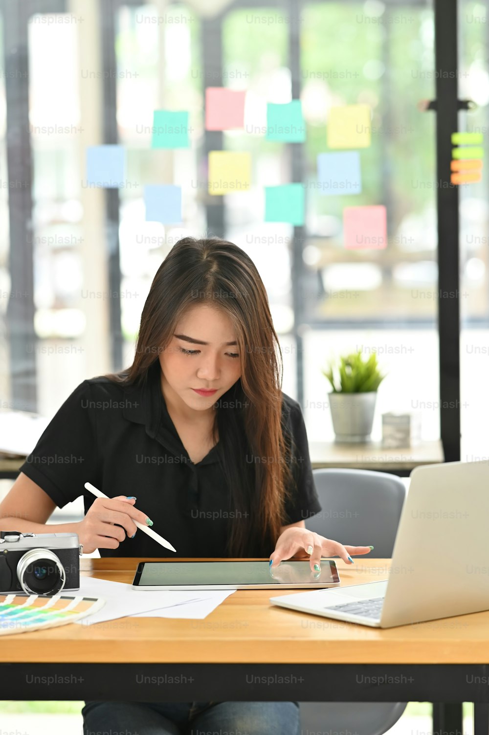 Young creative female working with tablet computer and stylus pen.