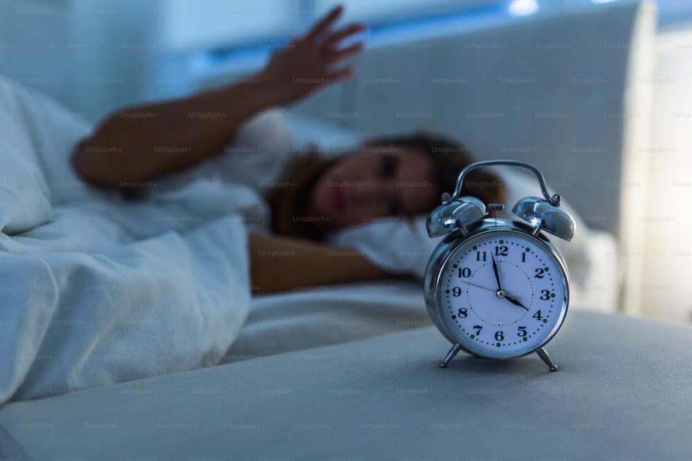 Woman lying in bed suffering from insomnia, Sleepless and desperate beautiful caucasian woman awake at night not able to sleep, feeling frustrated and worried suffering from insomnia in sleep disorder