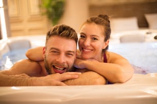 Our time for relax. Young couple in hot tub.