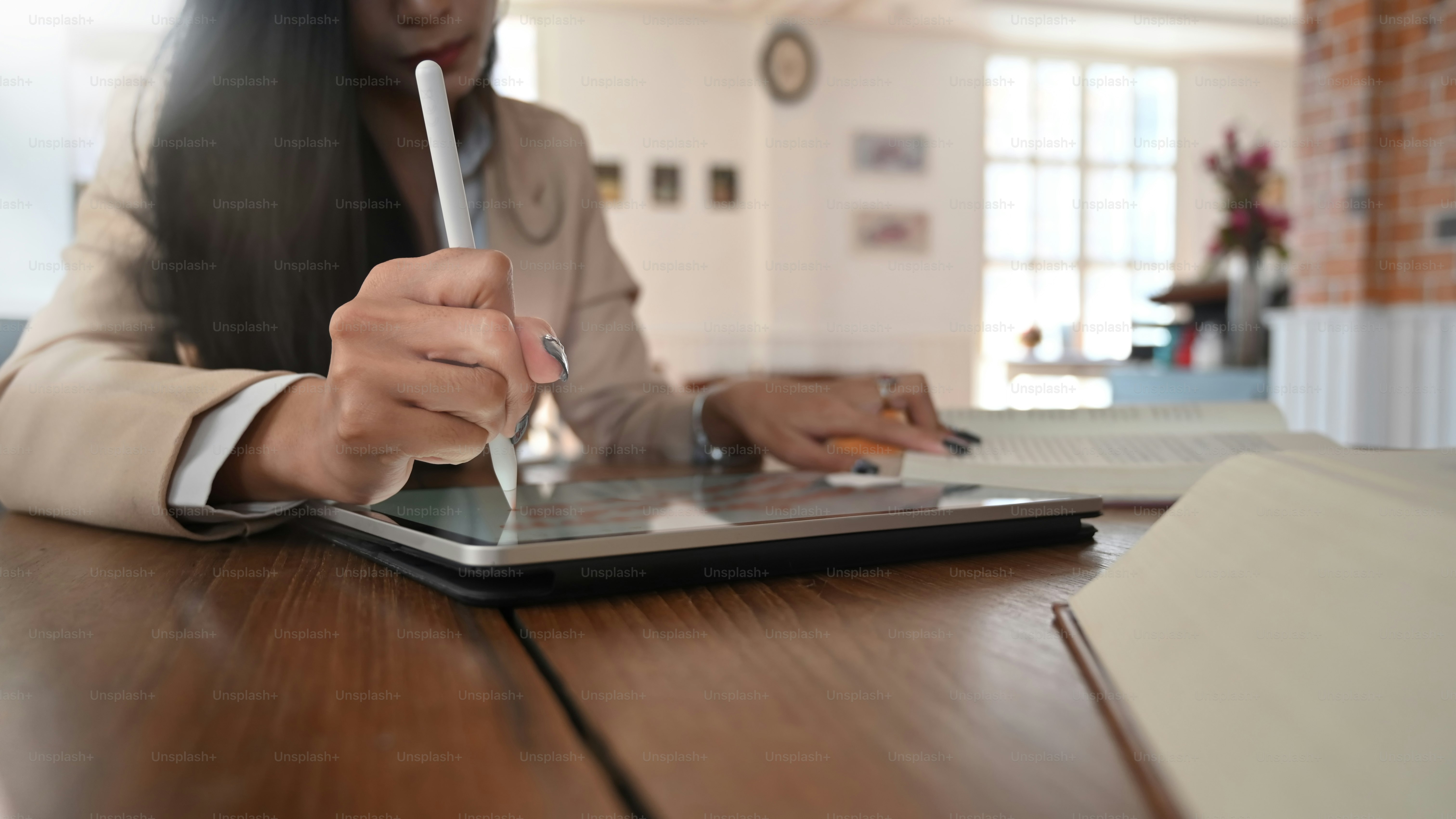 Cropped shot female editor book with using tablet and stylus pen.