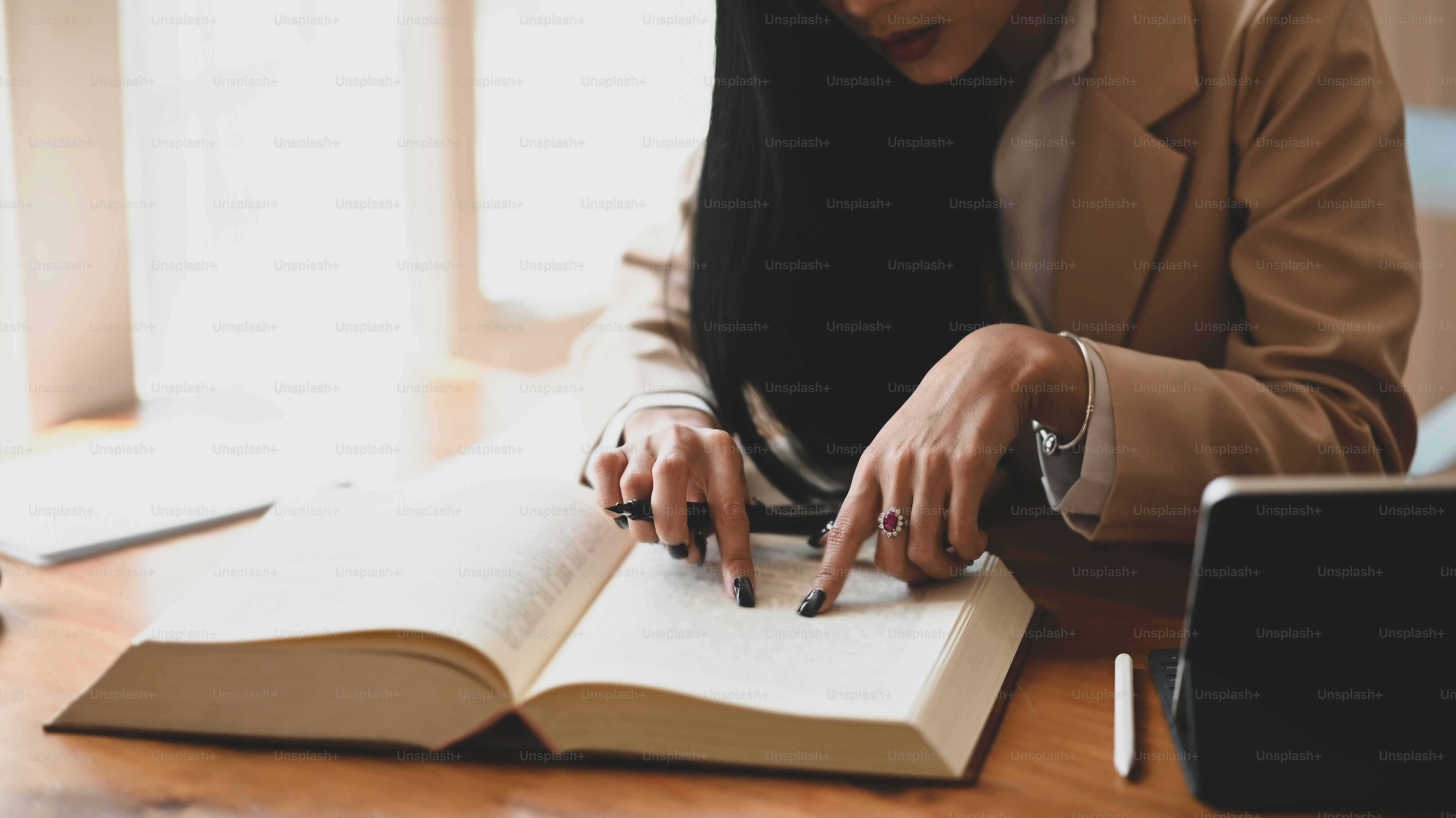 Libro de editor femenino recortado con el uso de tableta y lápiz óptico.