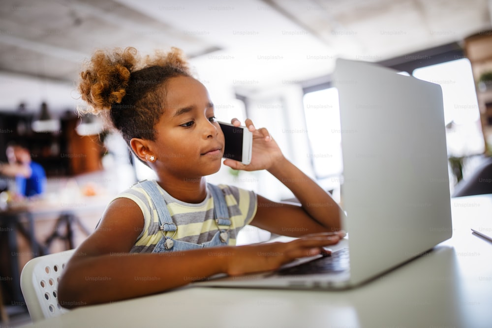 Bambini felici che trascorrono del tempo con il taccuino e la tecnologia moderna. Gioco, studio, concetto di divertimento