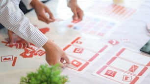 Group of professional UX graphic designer discussing the smartphone template project together in modern office room