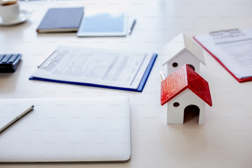 Formulário de contrato de compra de casa e terreno na mesa de corretagem de uma empresa imobiliária.