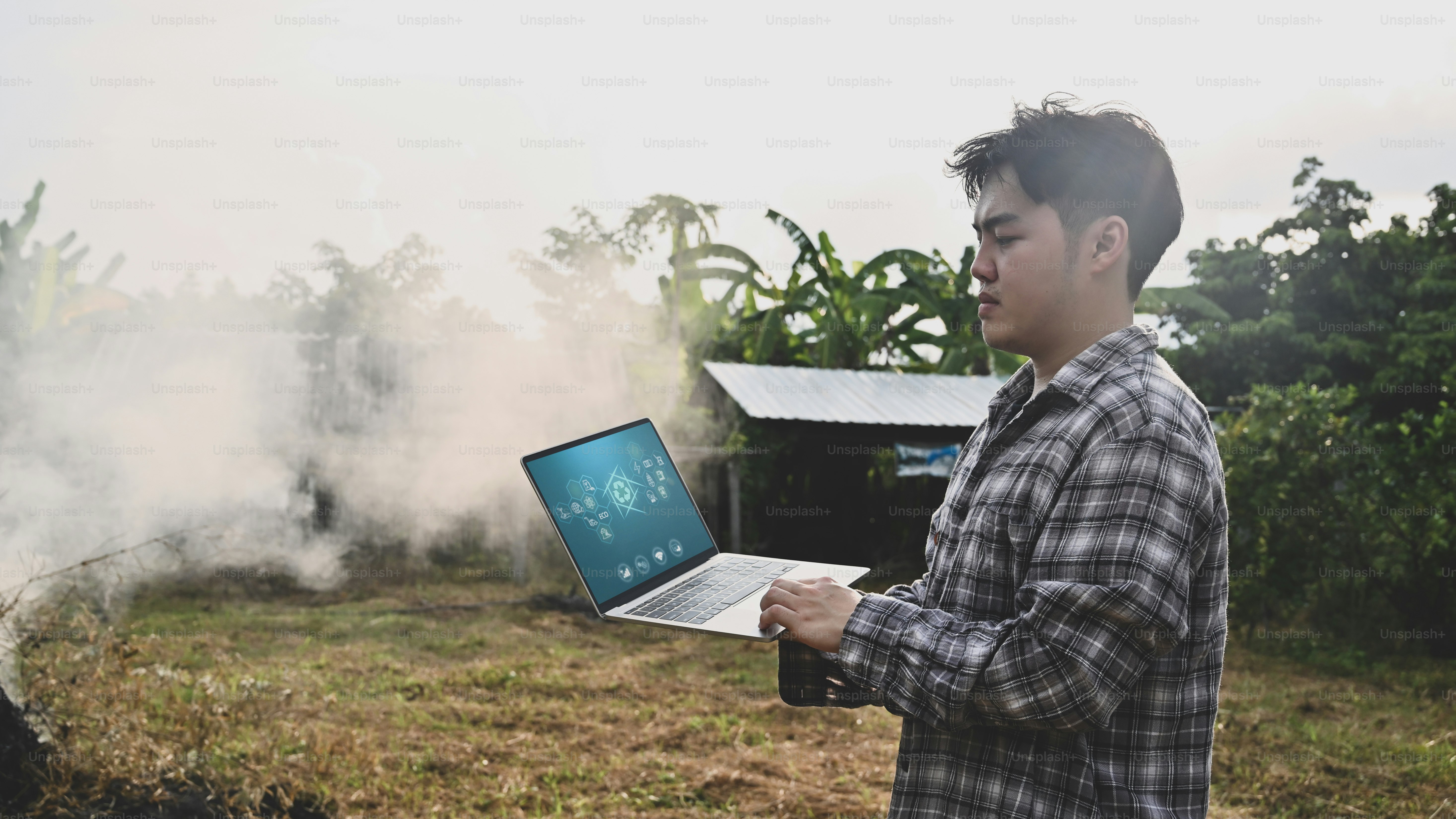 Agriculture technology concept, man with laptop standing on agriculture field.