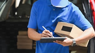 Delivery man checking list on tablet computer.