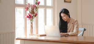 Portrait of young professional businesswoman working on her project with tablet in modern office room