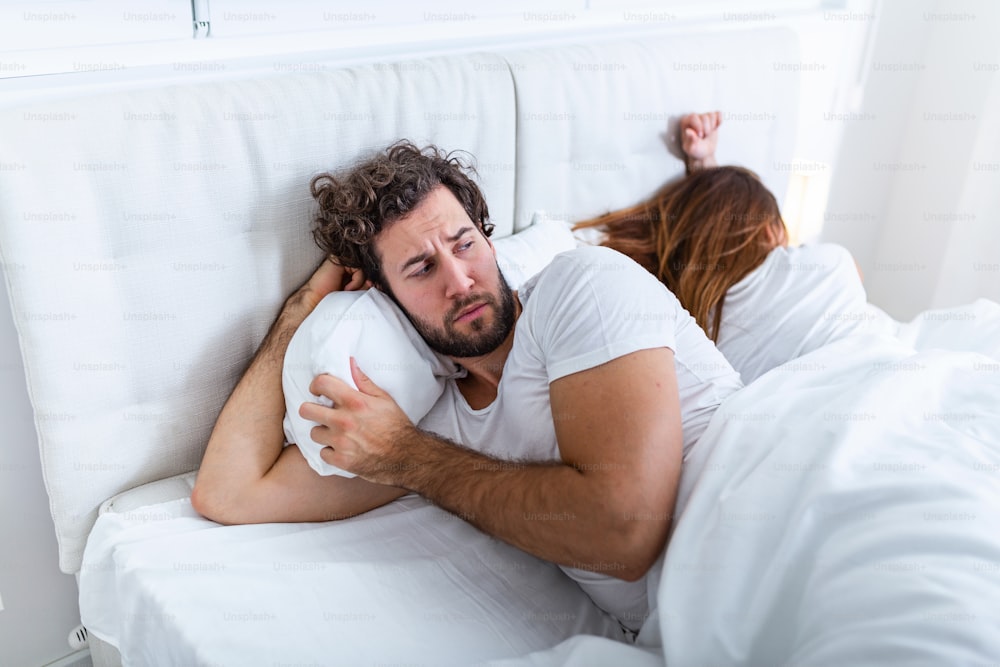 관계 개념입니다. 침대에 누워 있는 젊은 부부. 침대에서 싸우는 커플. 부부 간의 관계와 문제에 대한 개념. 성적 좌절. 연인들은 서로를 무시한다.