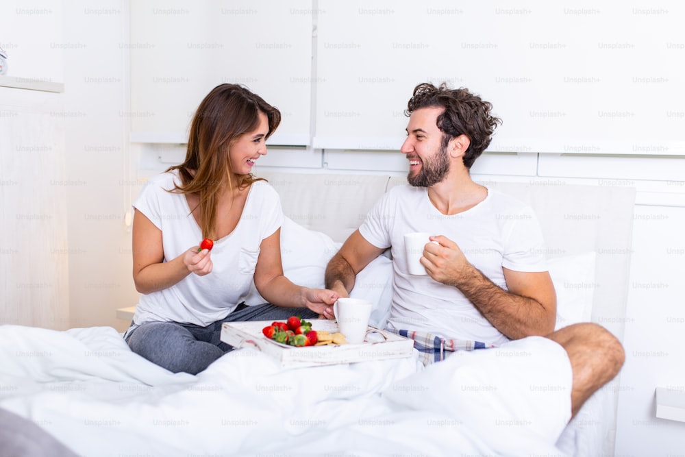 침대에서 낭만적 인 아침 식사 남자는 그의 여자를 위해 준비, 그녀는 매우 행복했다, 침대에서 아침 식사와 커피를 먹는 침대에서 젊은 아름다운 커플