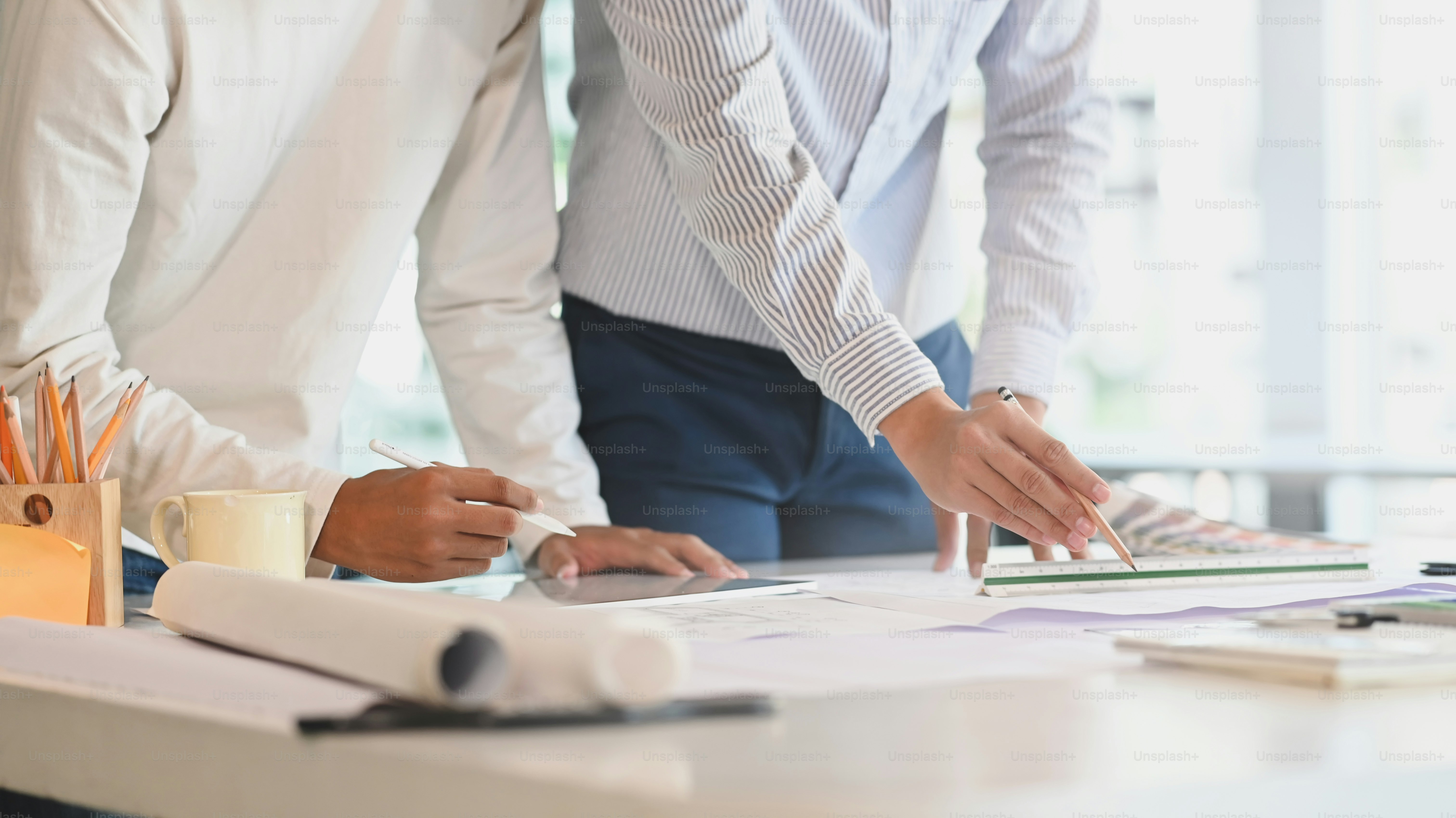 Cropped architect or engineer working in office with blueprints architectural closeup shot.