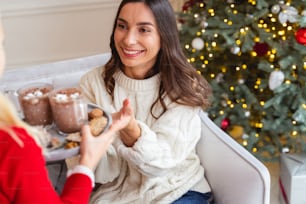 Cropped photo of a girl holding a tray in front of her pretty mother