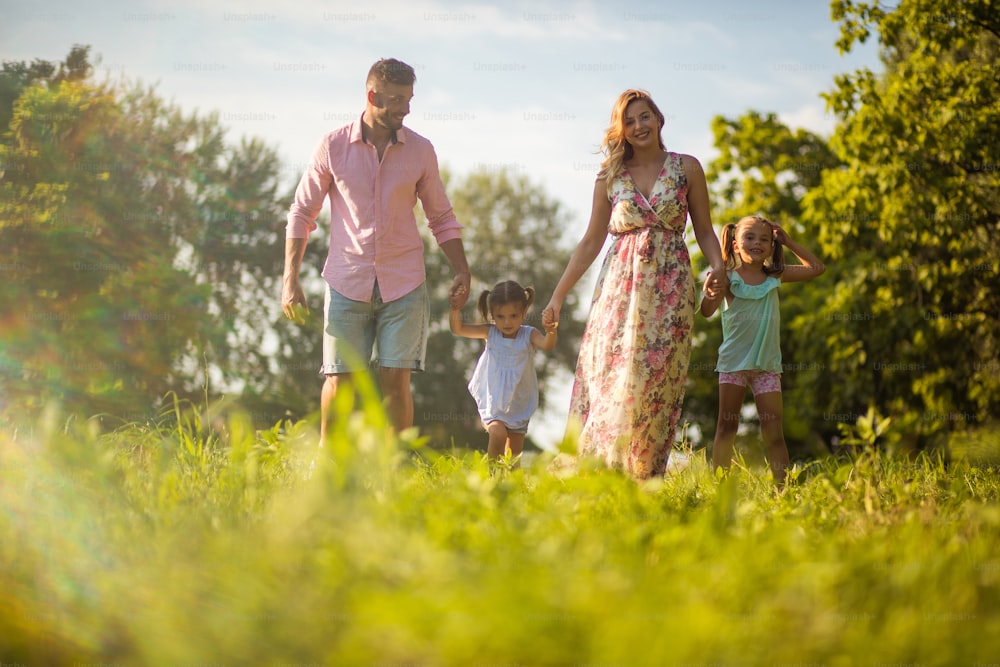 We never go a summer without nature vacation. Parents with daughters walking together.