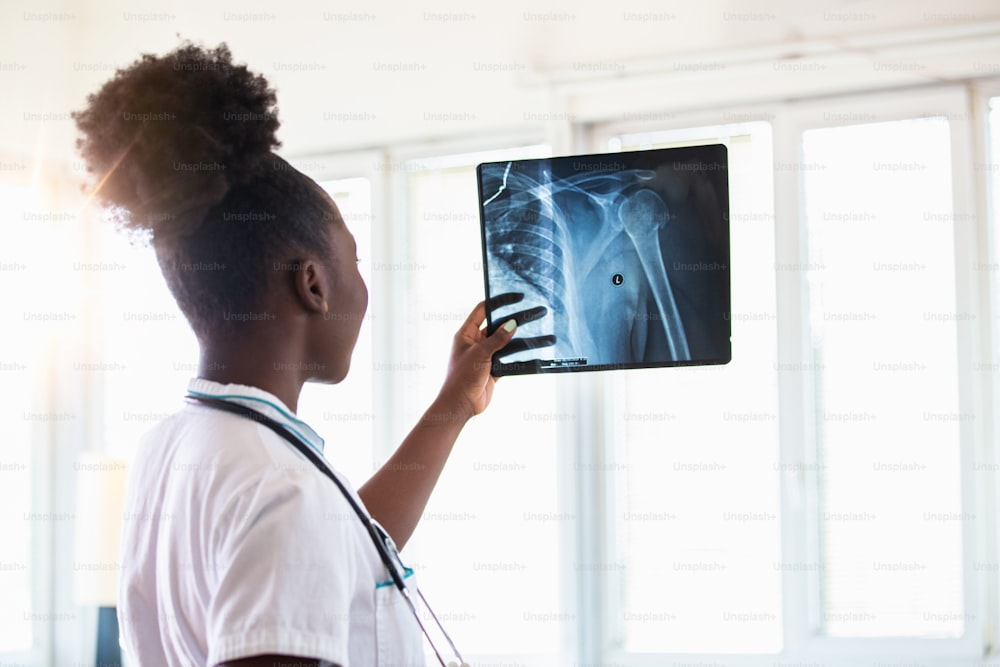 Imagen de película de rayos X con médico para diagnóstico médico y radiológico en la salud del paciente femenino en la enfermedad y la enfermedad del cáncer de hueso, concepto de servicio hospitalario de atención médica