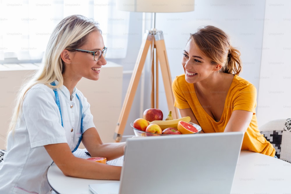 Female nutritionist giving consultation to patient. Making diet plan. Young woman visiting nutritionist in weight loss clinic Professional nutritionist meeting a patient in the office