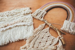 Stylish macrame and rainbow decoration on wooden table. Modern boho wall hanging and rope rainbow for baby room or simple stylish girl room. Wall macrame decor