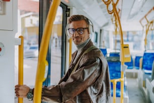 Smiling gentleman listening to music in public transport stock photo
