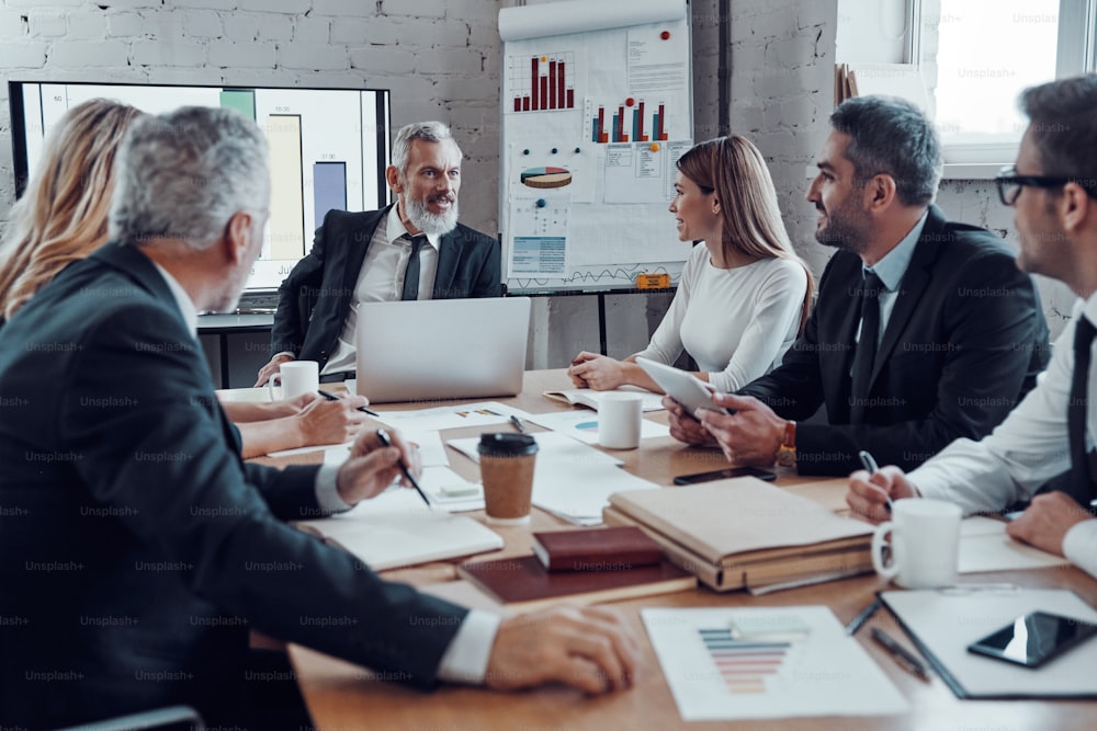 Modern business people communicating with each other while working together in the board room