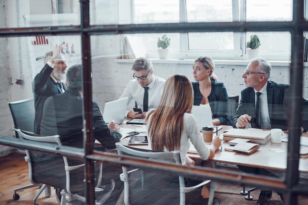 Coworkers discussing new business while working together with colleagues in the modern office