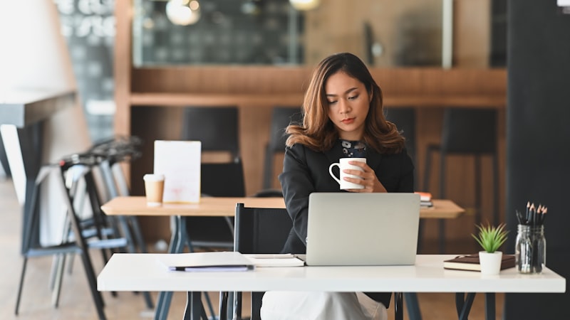 Professional working at a desk with laptop and coffee
