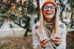 Happy lady laughing while using mobile phone stock photo
