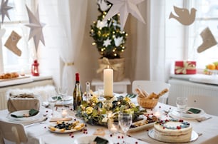 A decorated table set for dinner meal at Christmas time.