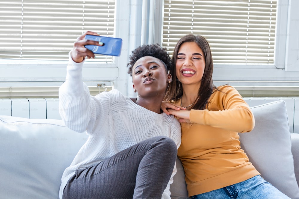 Happy young best friends having fun and smiling. Friends smiling for selfie.making selfie photo on smart phone. African American and caucasian best friends laughing and taking selfie with mobile phone