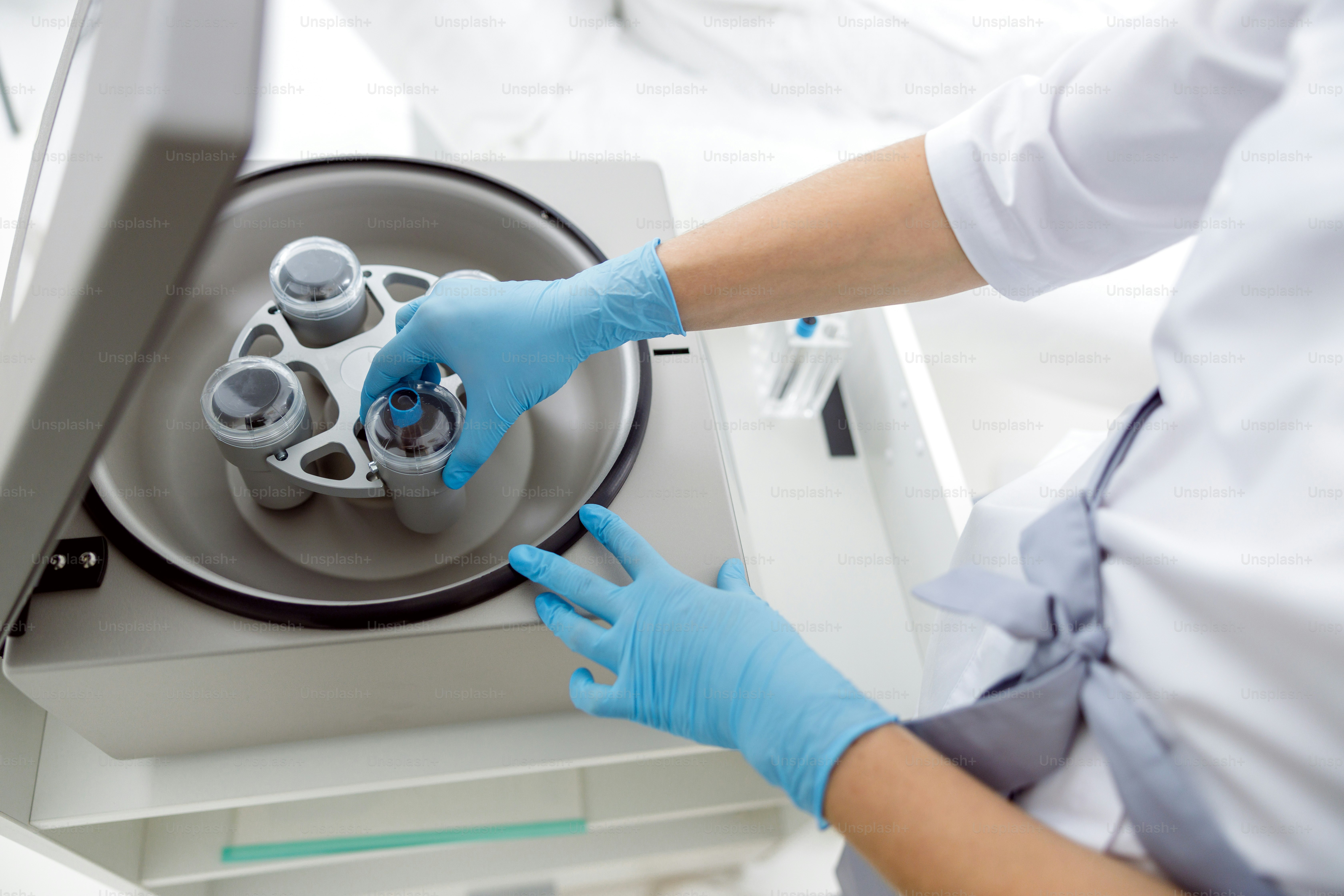 Doctor putting test tube in a centrifuge for separation processing ...