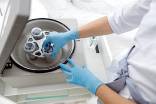 Doctor putting test tube in a centrifuge for separation processing